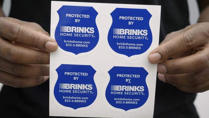 Brinks Home Security stickers held up by my colleague.